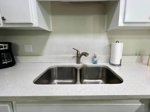 This fully equipped kitchen features stainless steel appliances, a large counter with seating, and a cozy dining nook framed by natural light. Whether you’re cooking a full meal or enjoying takeout, this space is perfect for gathering and dining in.
