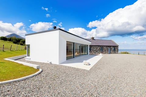 Contemporary extension, reconstructed original cottage and Slievemore mountain