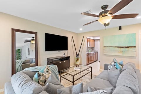 Living room features a large sectional sofa and wall mounted Roku TV,
