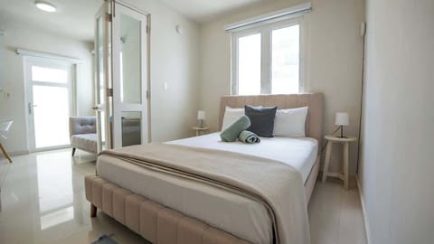 A queen bed and calming tones create a comfortable place to recharge.