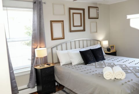 A bright master bedroom with a king size bed and room darkening curtains. 