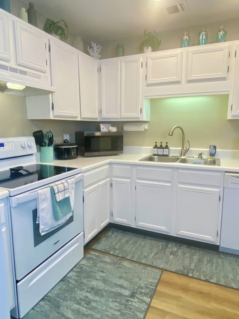 Fully stocked kitchen with stove, microwave, slow cooker, rice cooker and more