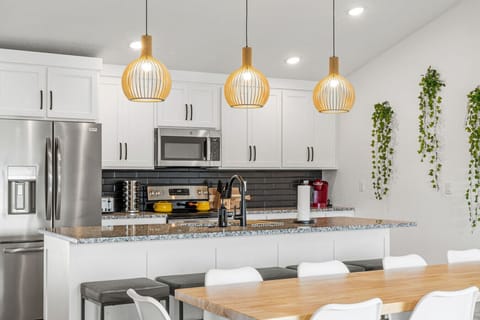 Fully stocked kitchen with modern appliances and bar seating for casual meals or morning coffee.
