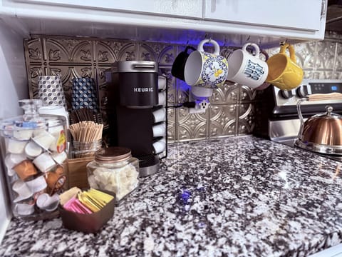 Coffee bar with regular and decaf, creamer, mugs and to-go cups.