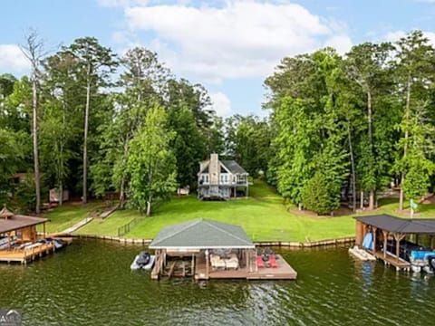 View from the lake of the boathouse and house including the large flat yard providing lots of room for outdoor activites.