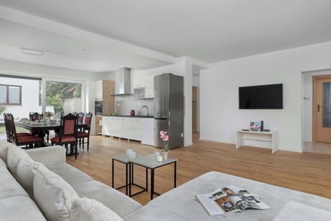 Bright and spacious living room with large windows and stylish wooden flooring.