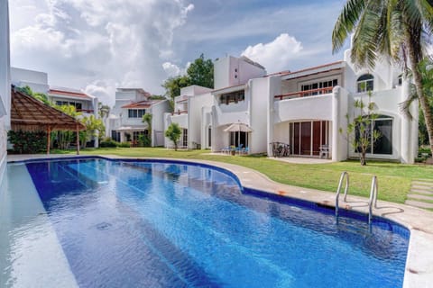 Dive into the refreshing shared pool, surrounded by lush tropical landscaping.