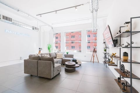 Welcome to our bright living room, with natural light, cozy seating, and a big TV.