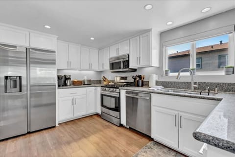 Second Floor: kitchen with stainless steel appliances, dining area, and balcony views.