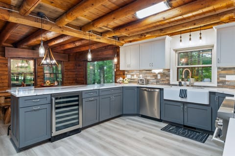 A modern chef’s kitchen with sleek gray cabinetry, wine cooler, and spacious island blending style with convenience.