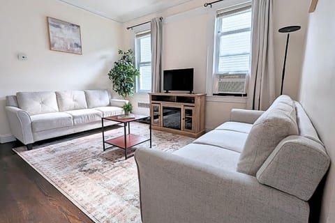 Unwind and share laughs after exploring NYC – Spacious living room with cozy seating, perfect for families or business groups.