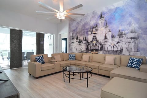 Stylish living area with L-shaped sofa, Smart TV, sliding doors to pool deck