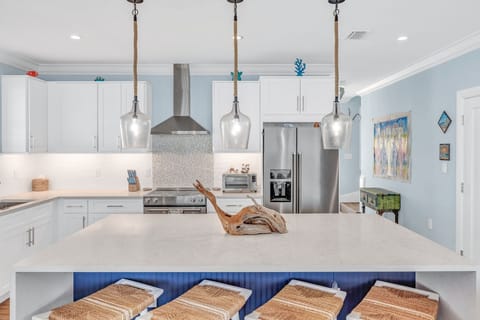 This stunning kitchen includes stainless steel appliances, ample counter space, and island seating—ideal for preparing fresh seafood after a day of Florida Keys fishing adventures.