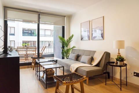 Relax in a stylish living area with chic decor and a cozy balcony view, perfect for unwinding.