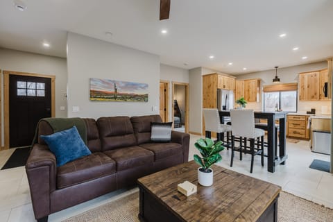 The living room invites you to relax with a plush sofa and a large smart TV