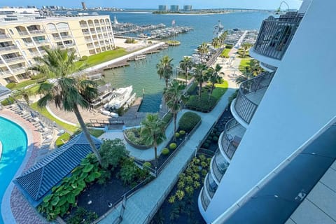 Experience waterfront living at its finest. This stunning view captures the serene marina, lush tropical landscaping, and a glimpse of the sparkling bay. The perfect blend of luxury and tranquility.