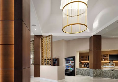 Step into a soaring lobby with elegant, golden lighting.