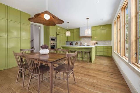 Our wonderfully-green kitchen features a large, granite-top island with three barstools, high-end amenities and appliances, and a walk in pantry. 