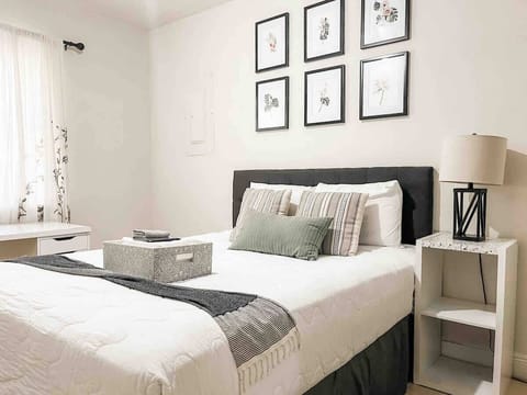 Bedroom with queen bed, smart tv, and desk. 