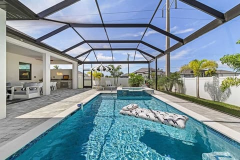 Screened pool with hot tub, lounge seating, and plenty of space to unwind in the Florida sun