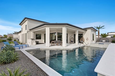 This stunning private yard features a sparkling heated optional pool and hot tub, covered outdoor dining area, sun loungers, lawn space, built-in fire pit & BBQ Grill!