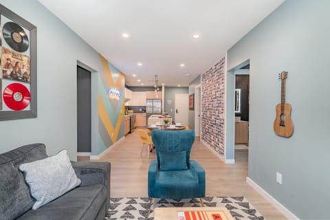 Living room with cozy seating, smart TV, and music-inspired décor featuring country album art.