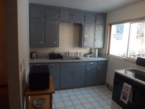 Full kitchen with refrigerator, stove, microwave, coffee makers, and most essentials