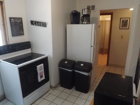 Full kitchen with refrigerator, stove, microwave, coffee makers, and most essentials