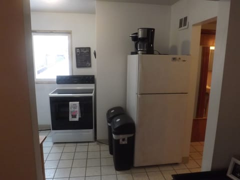 Full kitchen with refrigerator, stove, microwave, coffee makers, and most essentials