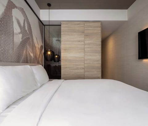 Sink into crisp linens beneath warm pendant lights and calm tones.