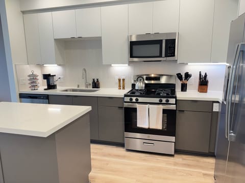 Experience extended comfort with a fully equipped kitchen featuring a coffee machine, stovetop, and microwave—everything you need for a seamless long-term stay.