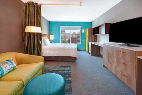 Unwind in a spacious suite with plush bed and big TV.