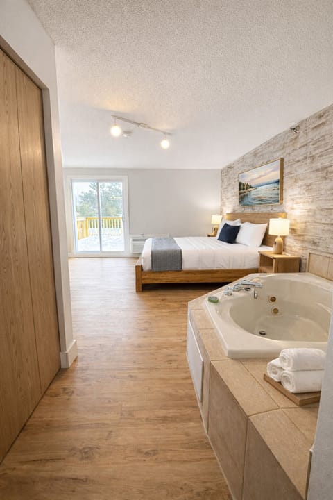 Spacious King Jacuzzi + Kitchette Suite with plush bedding, HDTV, and natural light.