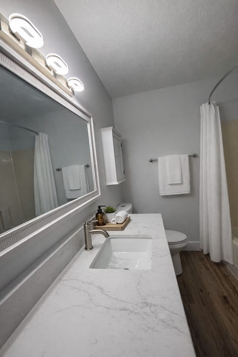 Updated guest bathroom offering sleek fixtures and fresh white linens.