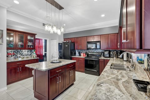 Cook meals in a bright kitchen with a large fridge.