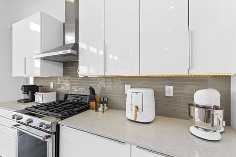 Full kitchen complete with stainless steel gas range, modern backsplash, and all the small appliances you need for effortless meals.