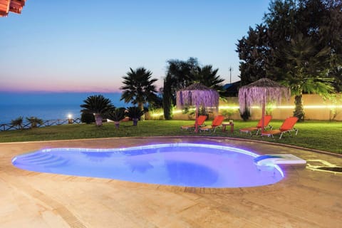 Private pool with relaxing sun loungers and garden views.