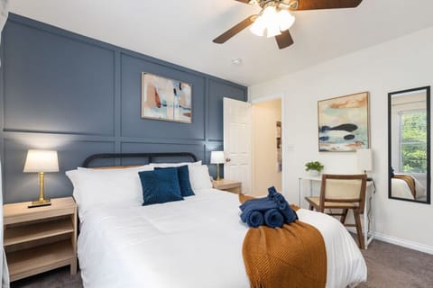 Calm bedroom with queen bed, blackout curtains, and dedicated workspace.
