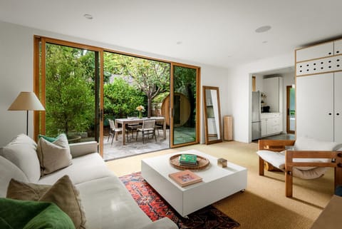 Relax in the living room while enjoying a refreshing view of lush greenery outside.