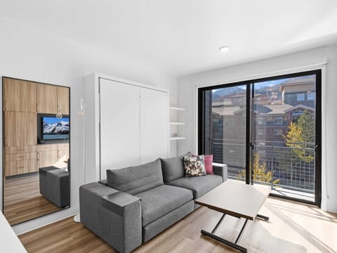 Studio living area with queen Murphy bed and balcony