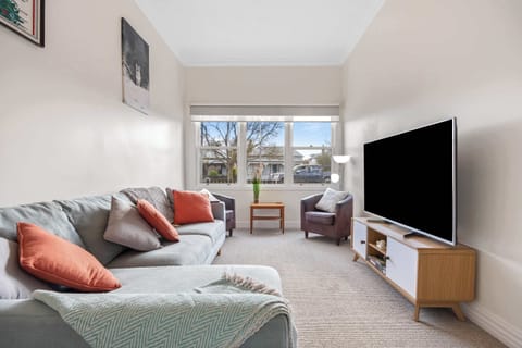 Living room with flat screen TV and ample seating.