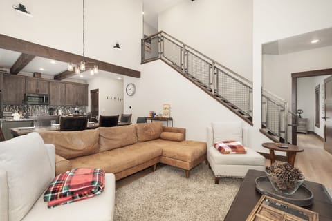 Relax in your stylish open-concept living space with soaring ceilings, exposed beams, and cozy seating perfect for unwinding after mountain adventures.