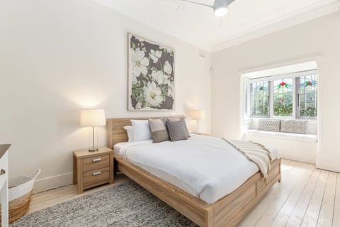 The primary bedroom offers a king bed, built-in wardrobes, and a bay window seat perfect for reading in the morning sun.