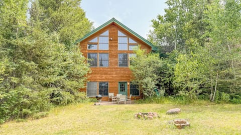 A charming log cabin nestled in the woods, surrounded by towering trees and natural beauty. The spacious deck and fire pit create the perfect setting for your peaceful retreat.