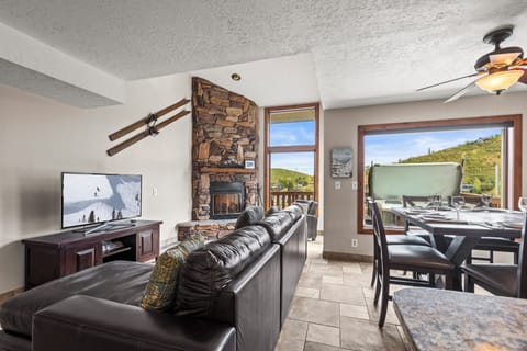 The open concept floor plan with a cozy living room, flat screen TV and gas fireplace.