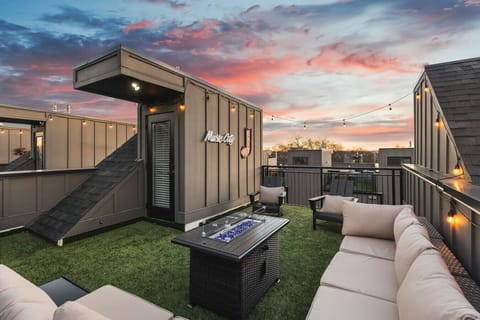 Spacious rooftop deck with a gas grill, fireplace, plenty of seating, and views of the city.