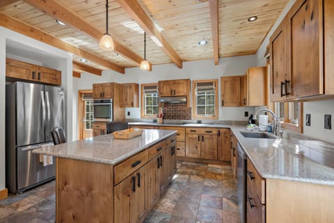 Spacious kitchen - offers tons of counter space, a walk-in pantry, stainless steel appliances, walk-out access to the back porch and propane barbecue grill, and hightop seating for two at the kitchen island.