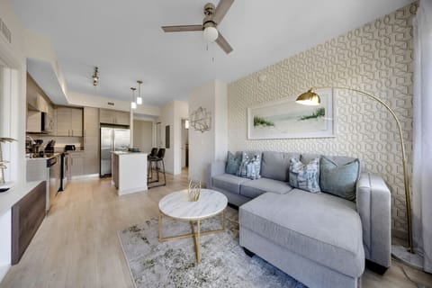 Open-Concept Living and Kitchen-Spacious open layout featuring a stylish living area with sectional sofa, chic décor, and a fully equipped modern kitchen. Bright, airy design perfect for comfort and entertaining.