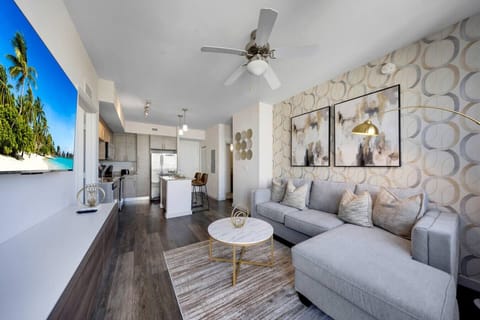 Stylish Open-Concept Living Room- Bright living area with a chic sectional sofa, modern décor, and flat-screen TV, seamlessly flowing into the kitchen and dining space.