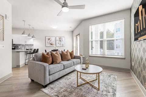 Modern Living Room-Bright and stylish living area with a cozy sofa, chic décor, and large windows. Features an open layout connecting seamlessly to the kitchen and dining space, perfect for relaxing or entertaining.